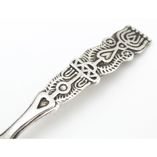 502 - A white metal Arts & Crafts teaspoon with hammered bowl and scroll detail to handle. Together with a... 