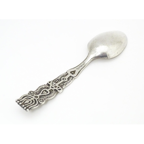 502 - A white metal Arts & Crafts teaspoon with hammered bowl and scroll detail to handle. Together with a... 