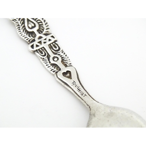 502 - A white metal Arts & Crafts teaspoon with hammered bowl and scroll detail to handle. Together with a... 