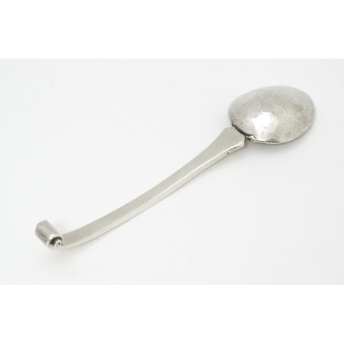 502 - A white metal Arts & Crafts teaspoon with hammered bowl and scroll detail to handle. Together with a... 