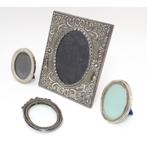 601 - Four assorted photograph frames  with silver and white metal surrounds to include an oval example wi... 