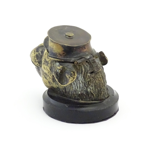 1192 - A Victorian novelty brass desk inkwell formed as the head of a monkey with glass eyes wearing a hat.... 