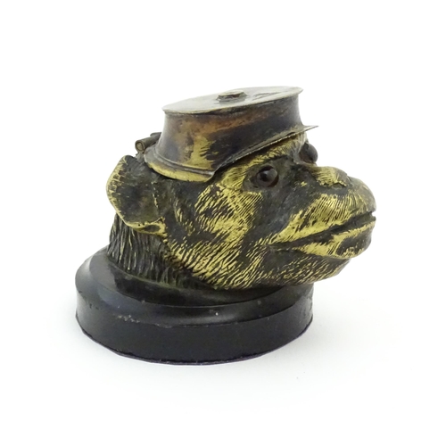 1192 - A Victorian novelty brass desk inkwell formed as the head of a monkey with glass eyes wearing a hat.... 