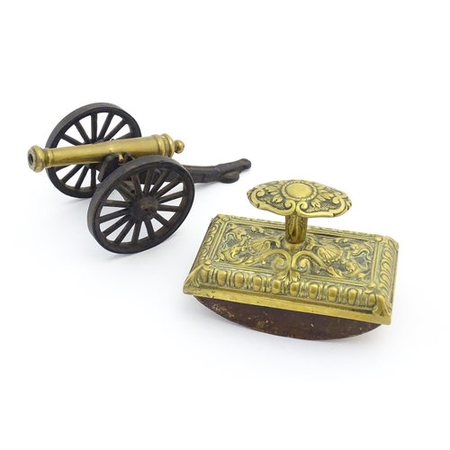 1193 - A late 20thC model desk cannon. Together with a Victorian desk blotter with cast brass detail to han... 