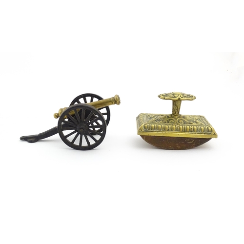 1193 - A late 20thC model desk cannon. Together with a Victorian desk blotter with cast brass detail to han... 