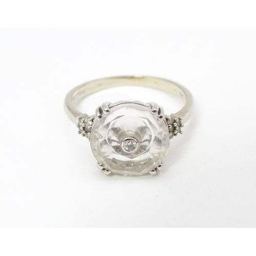 673 - A 10k white gold Lehrer Torus ring set with Bahia quartz and central diamond. Ring size approx M