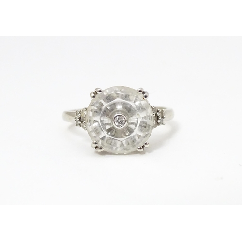 673 - A 10k white gold Lehrer Torus ring set with Bahia quartz and central diamond. Ring size approx M