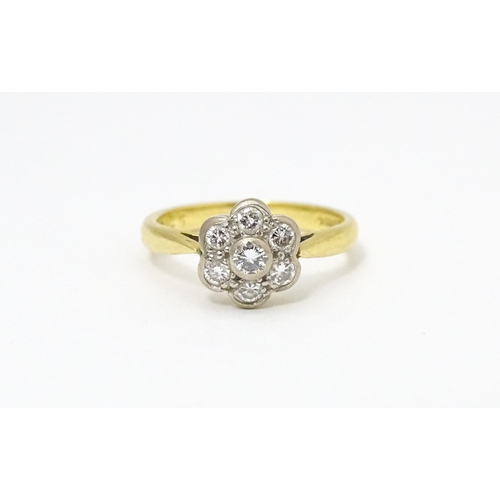 661 - An 18ct  gold ring set with 7 diamonds in a daisy setting. Ring size approx. H