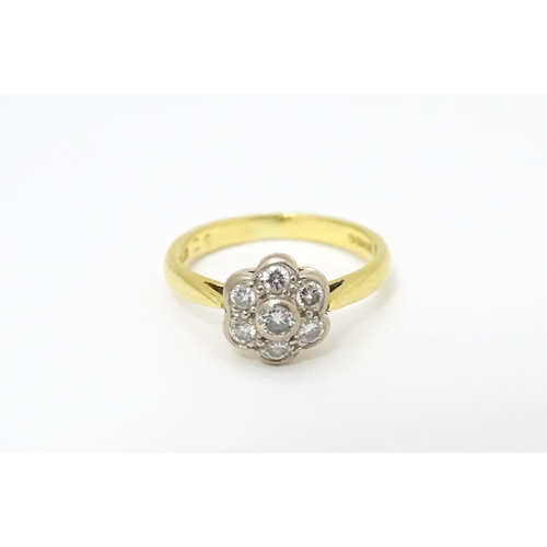 661 - An 18ct  gold ring set with 7 diamonds in a daisy setting. Ring size approx. H