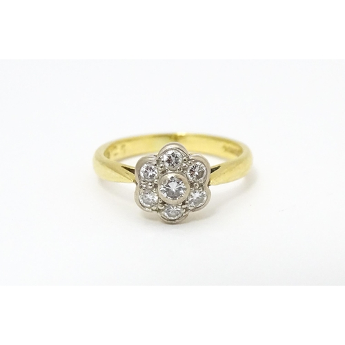 661 - An 18ct  gold ring set with 7 diamonds in a daisy setting. Ring size approx. H