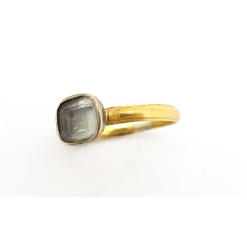 674 - A 19thC yellow metal ring set with central white stone. Ring size approx J