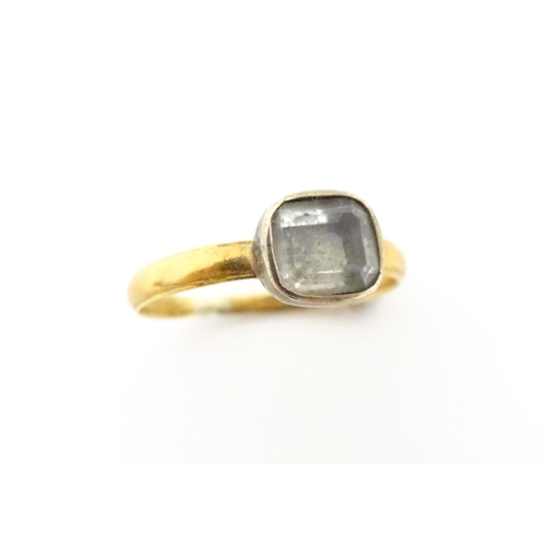 674 - A 19thC yellow metal ring set with central white stone. Ring size approx J