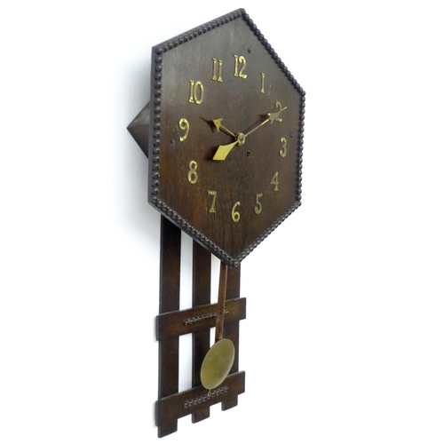 9 - An Arts and Crafts style oak wall clock, the hexagonal dial with Arabic brass numerals and stylised ... 