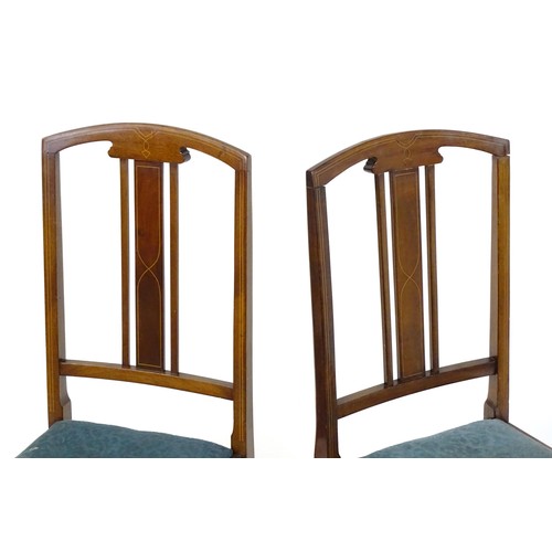 12 - A pair of Edwardian mahogany side chairs with satinwood inlaid stringing, the chairs raised on taper... 