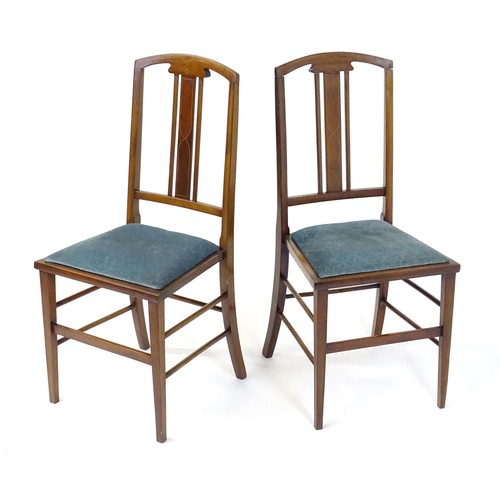 12 - A pair of Edwardian mahogany side chairs with satinwood inlaid stringing, the chairs raised on taper... 