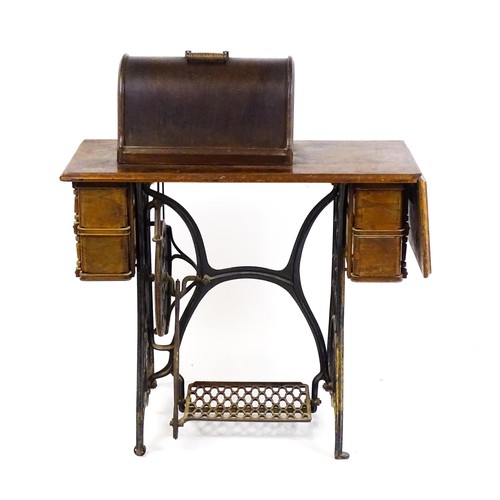 16 - An early 20thC singer sewing machine mounted upon a table, with four short drawers, a drop flap and ... 