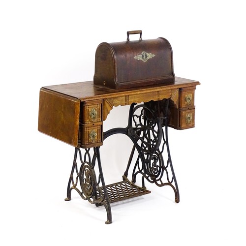 16 - An early 20thC singer sewing machine mounted upon a table, with four short drawers, a drop flap and ... 
