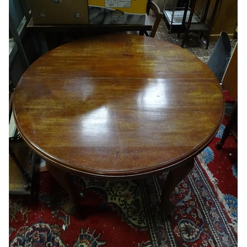 19 - A mahogany oval dining table with cabriole legs and pad feet. Approx 45 3/4
