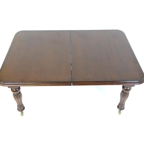 24 - A late 20thC / early 21stC mahogany dining table with a moulded top and rounded corners above reeded... 
