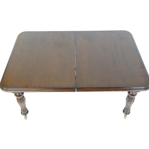 24 - A late 20thC / early 21stC mahogany dining table with a moulded top and rounded corners above reeded... 