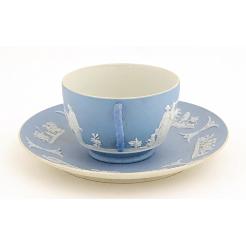 40 - A Wedgwood Jasperware tea cup and saucer decorated with classical figures in relief. Cup approx. 2