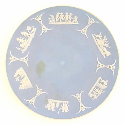 40 - A Wedgwood Jasperware tea cup and saucer decorated with classical figures in relief. Cup approx. 2
