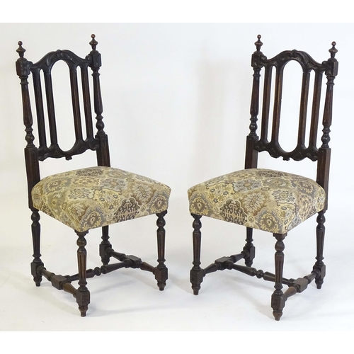 78 - A pair of late 19thC carved oak side chairs surmounted by turned finials and having carved cresting ... 