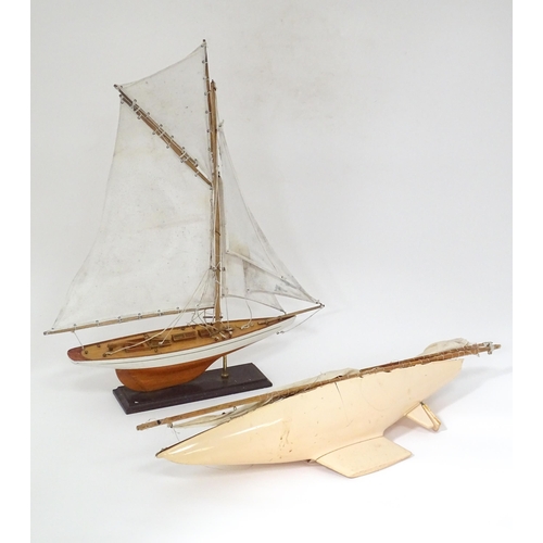 90 - A mid 20thC wooden pond yacht / model boat on stand, with painted finish and cotton sails, together ... 