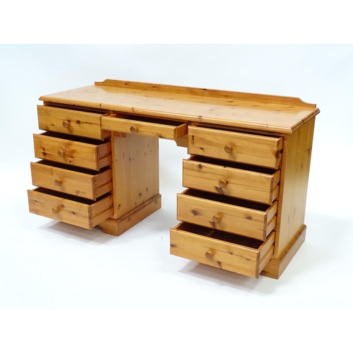 96 - A pine double pedestal desk with a moulded top and a shaped upstand, having two banks of four short ... 