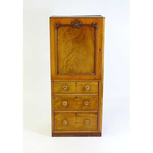 107 - A late 19thC / early 20thC mahogany cabinet with a panelled door above three short drawers with turn... 