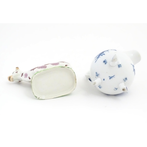 137 - A Swansea cow creamer. Together with a Continental blue and white three footed jug decorated with fl... 