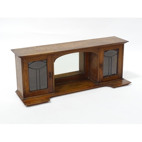 1 - An early 20thC oak table top cabinet, with two leaded glass doors and a central mirror. Top section ... 