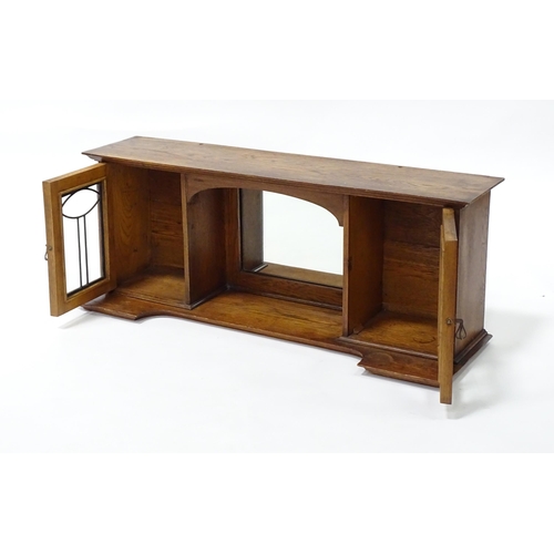 1 - An early 20thC oak table top cabinet, with two leaded glass doors and a central mirror. Top section ... 
