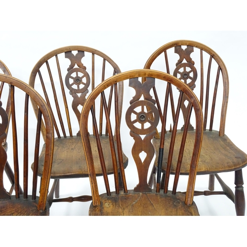 98 - A set of five late 19thC / early 20thC wheelback dining chairs with shaped elm seats and raised on t... 