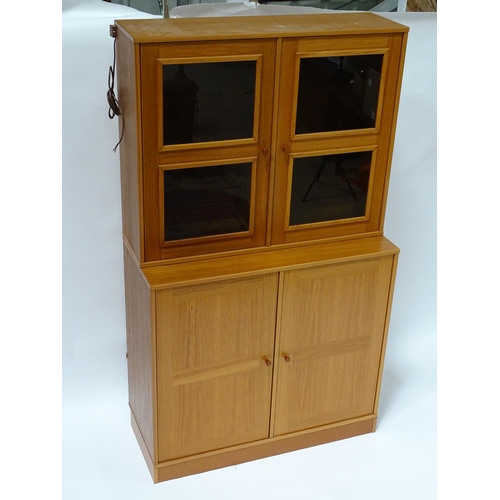 834 - Two c1970s teak cupboards, each consisting of a glazed (tinted) shelving unit above a floor standing... 