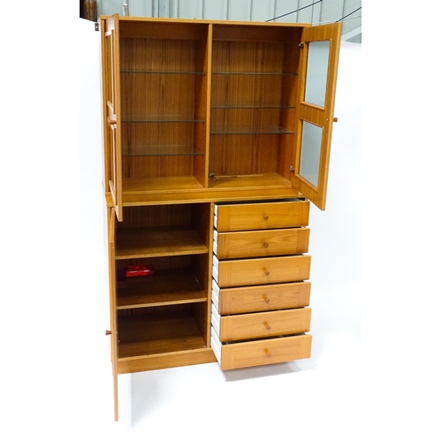 834 - Two c1970s teak cupboards, each consisting of a glazed (tinted) shelving unit above a floor standing... 