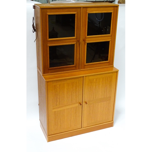 834 - Two c1970s teak cupboards, each consisting of a glazed (tinted) shelving unit above a floor standing... 