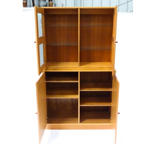 834 - Two c1970s teak cupboards, each consisting of a glazed (tinted) shelving unit above a floor standing... 