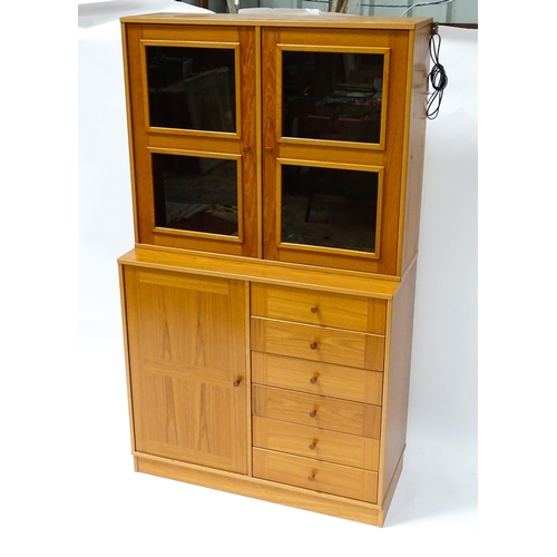 834 - Two c1970s teak cupboards, each consisting of a glazed (tinted) shelving unit above a floor standing... 