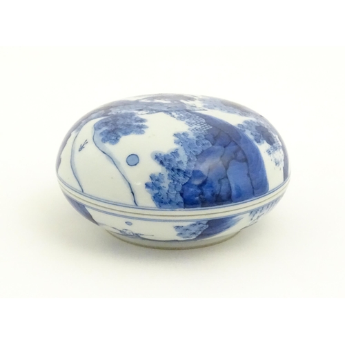 23 - A Chinese blue and white ink pot and cover of circular form, decorated with figures in a landscape. ... 