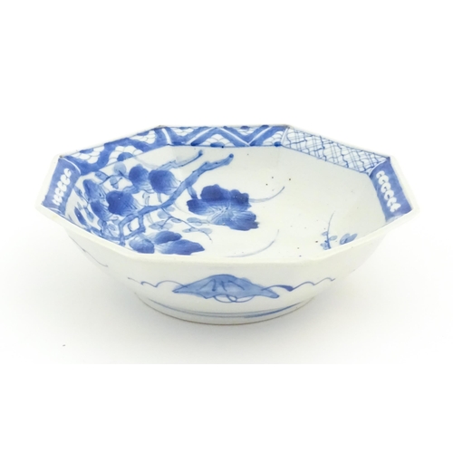 24 - An Oriental blue and white bowl of octagonal form decorated with flowers and blossom, with a pattern... 