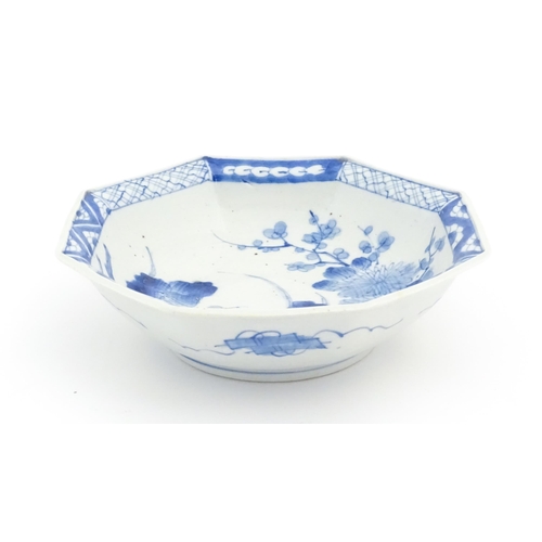 24 - An Oriental blue and white bowl of octagonal form decorated with flowers and blossom, with a pattern... 