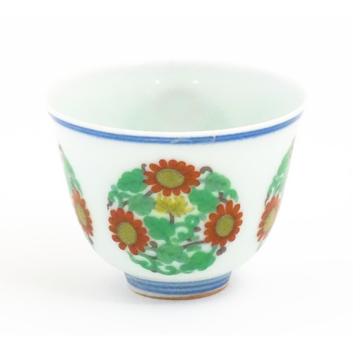 27 - A Chinese wine cup decorated with floral roundels. Character marks under. Approx. 1 3/4