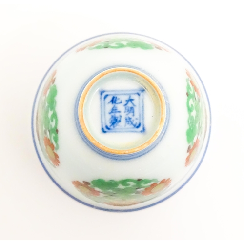 27 - A Chinese wine cup decorated with floral roundels. Character marks under. Approx. 1 3/4