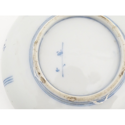 40 - A pair of Oriental blue and white dishes each depicting a figure on a bridge looking out to sea with... 