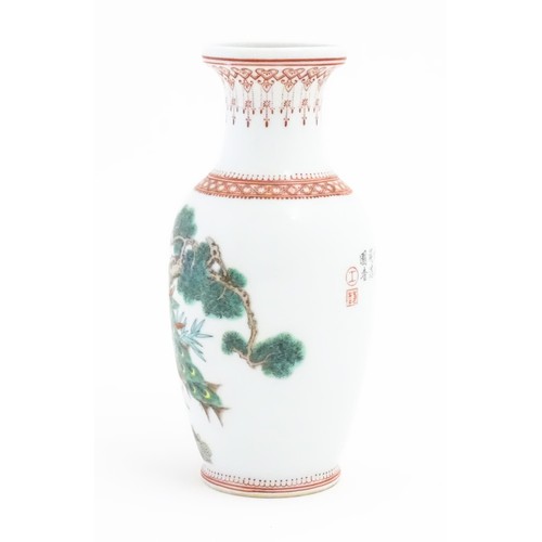 62 - A Chinese vase decorated with a peacock perched on a branch with flowers and foliage. Marked under. ... 