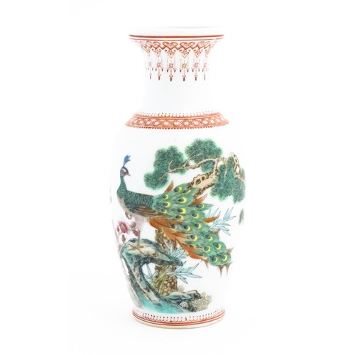 62 - A Chinese vase decorated with a peacock perched on a branch with flowers and foliage. Marked under. ... 