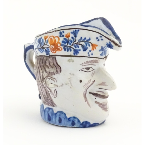 73 - A French faience character / Toby jug, possibly modelled as Mr Punch. Approx. 3 1/4