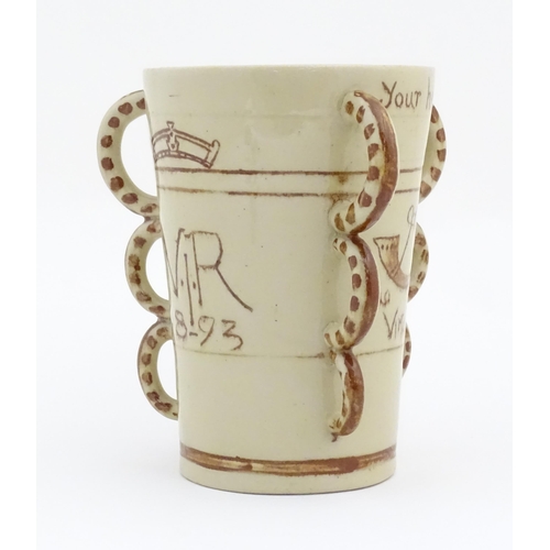 81 - A beaker / tyg  with three loop handles, the body with hand painted decoration depicting a lion ramp... 