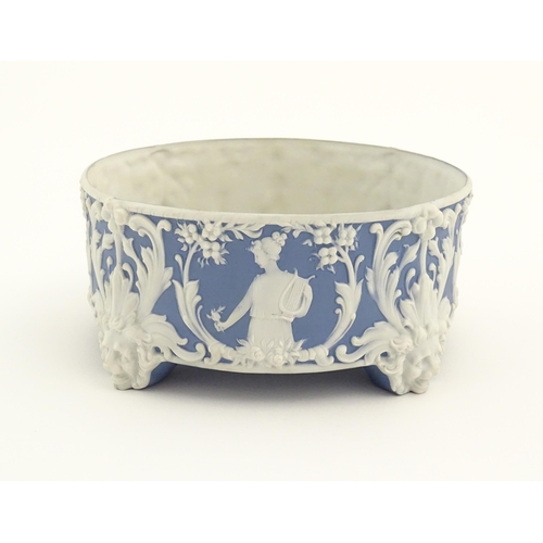 158 - A blue and white Jasperware style plant stand with relief Pan detail and scrolling foliage. Approx. ... 